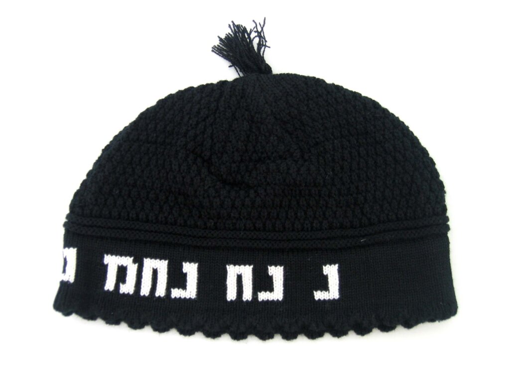כיפת סרוגה בעיצוב פריק עם פחזנית בראש, עיטור רקום בלבן סביב השוליים וסיום משונן. מבتهاד מלפנים.