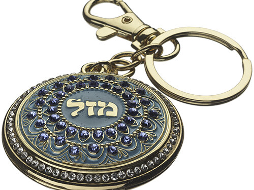 מחזיק מפתחות עגול משובץ עם המילה מזל במרכז, טבעת מפתחות ותפס מתכת מזוויות צילום אלכסונית.