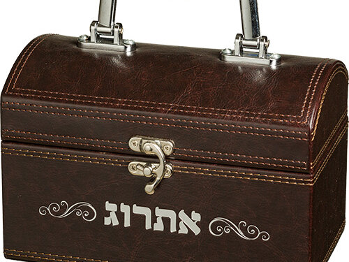 קופסת אתרוג דמויית עור בעיצוב תיבה עם ידית מתכת עליונה, מנעול קדמי, תפרי הצحה ועיטור כיתוב אתרוג.